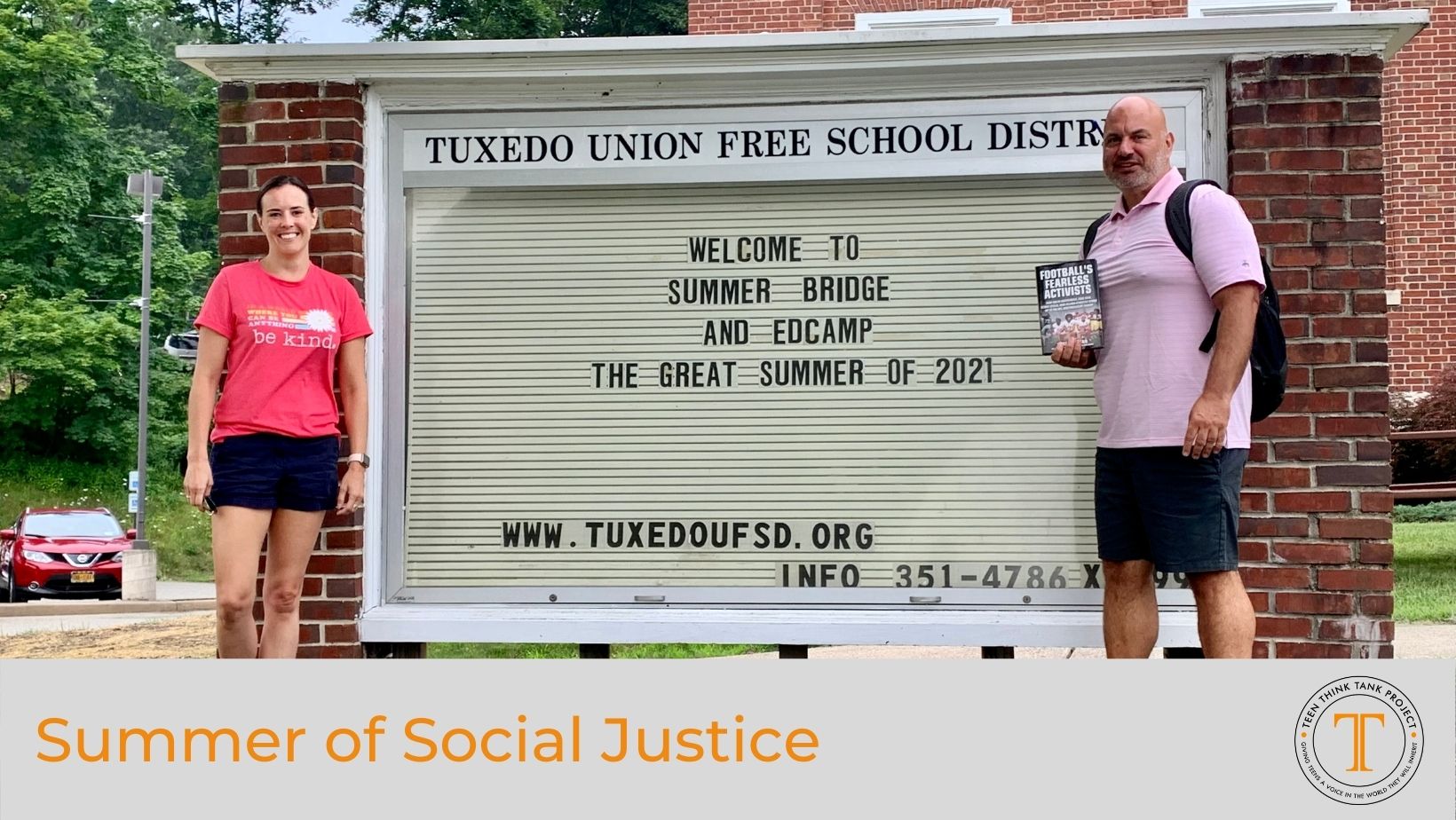 Man and woman standing in front of a school sign